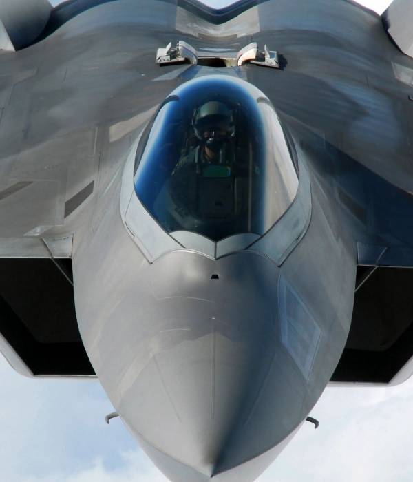 A fighter jet with the cockpit open looking up at the camera.